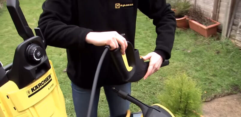 Person Holding Pressure Washer Hose And Spray Trigger