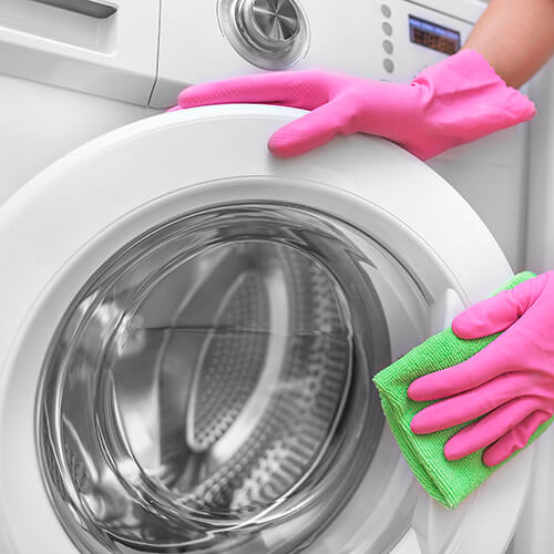 Washing Machine Door Being Cleaned With Sponge