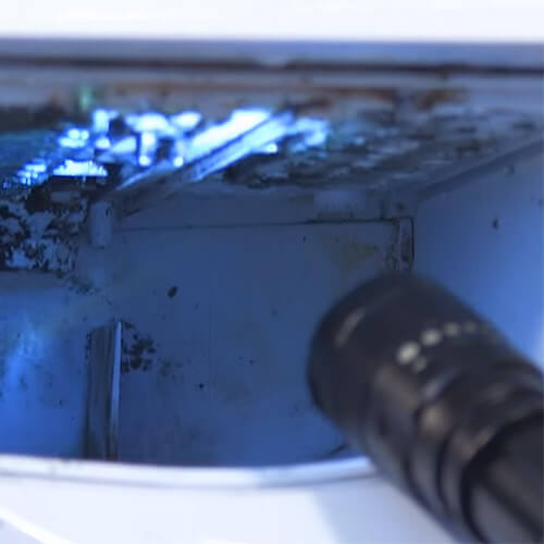 Torch Shining Light Into Mouldy Detergent Drawer Housing