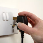 Hand Unplugging Plug From Socket