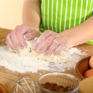 Woman Kneading Cake Mixture On Bench