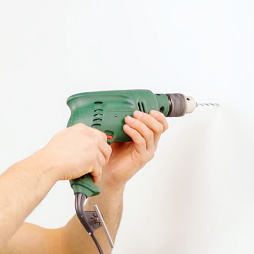 Drill Drilling Into White Wall