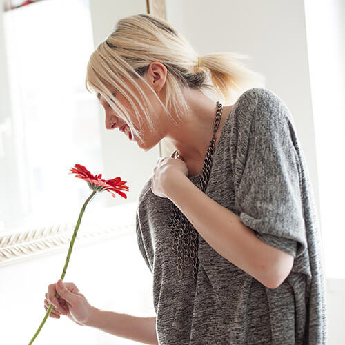 Woman Smelling Red Gerbera Flower