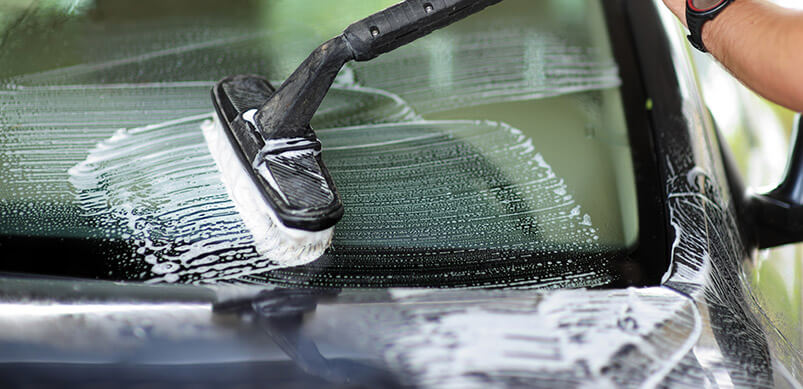 Man Washing Car With Pressure Washer