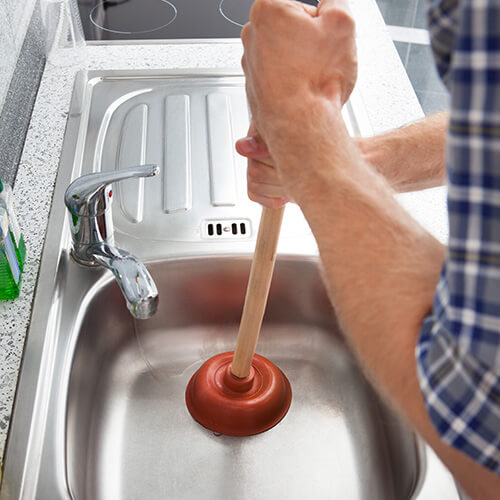 Male Using Plunger to Unblock Sink