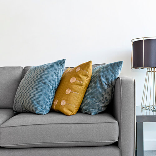 Grey Sofa With Coloured Cushions and Lamp