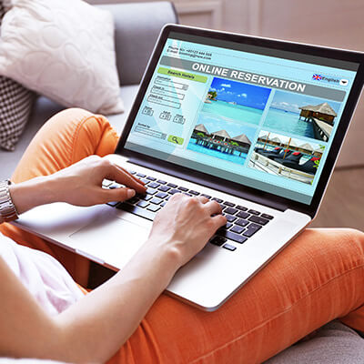 Woman Using Laptop To Book Hotel Online