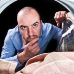 Confused Man Looking Inside Washing Machine