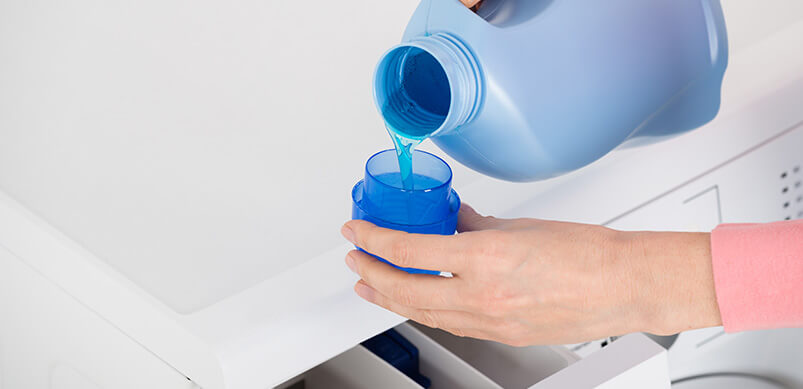 Hand Pouring Detergent In Washing Machine Draw