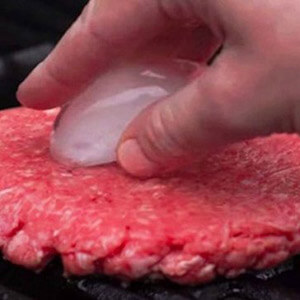 Person Putting Ice Cube On Burger Patty