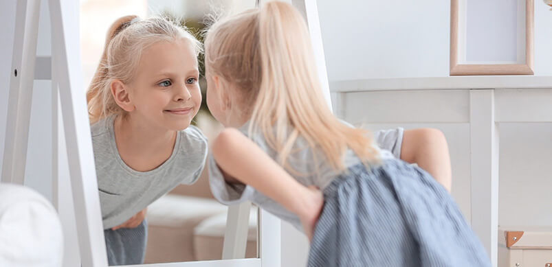 Girl Looking at Herself In Stand Up Mirror