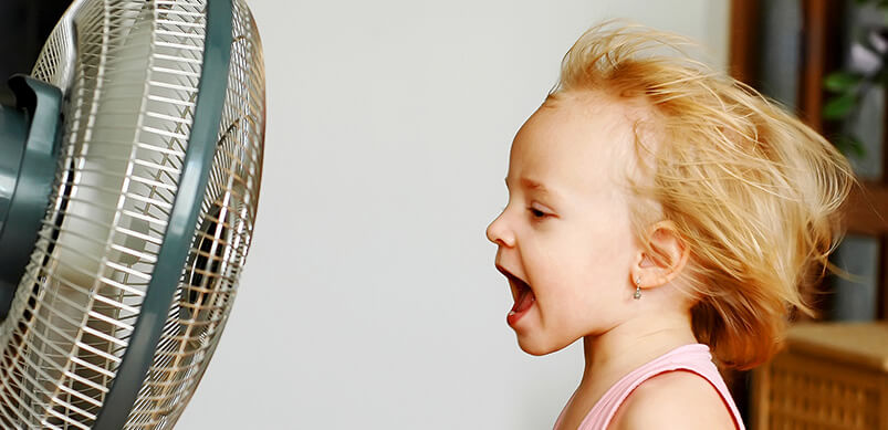 Girl Sitting In Front Of Fan With Hair Blowing