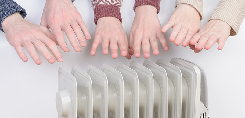 Hands Hovering Over Heater 