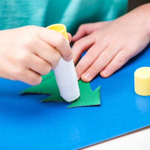 Childs Hands Sticking Glue To Pictures