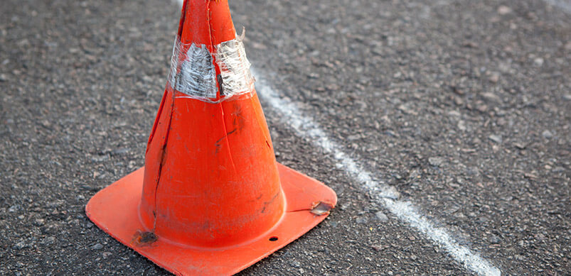 Cracks On Road With Hazard Cone