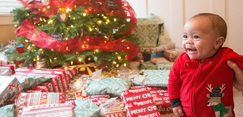 Baby Next To Christmas Presents