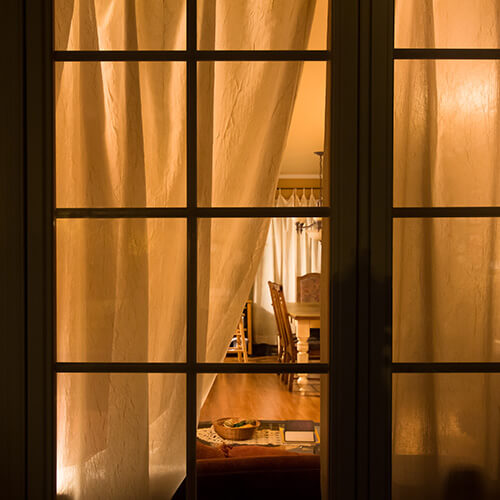 Open Curtain Showing Living Room With Light On