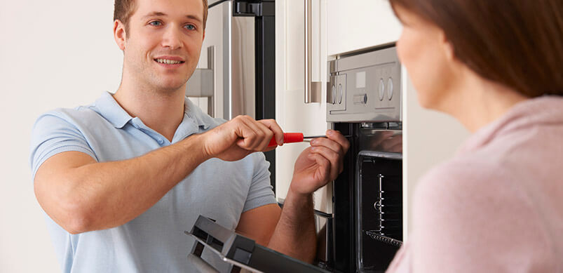 Man And Woman Fixing Oven