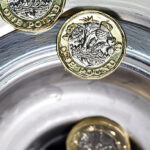 Pound Coins Being Rinsed Down Drain