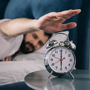 Man Turning Off Alarm In Morning