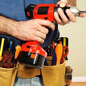 Man Wearing Toolbelt Holding Drill