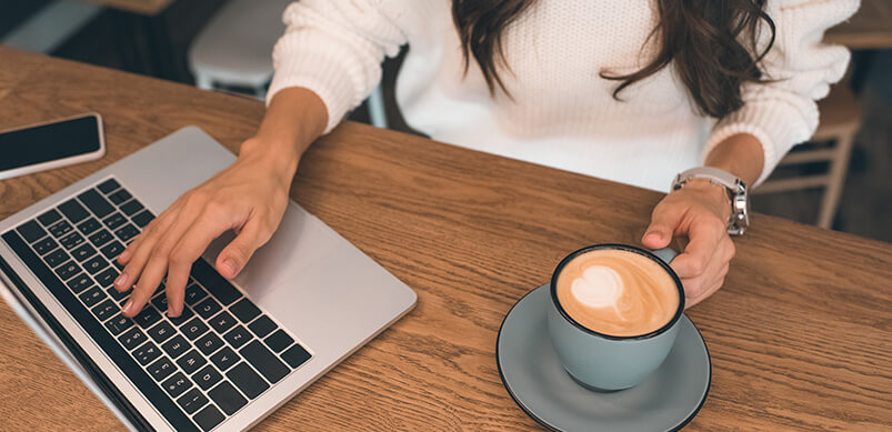 Woman With Laptop And Coffee Cup On Desk