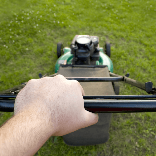 Close Up Of Hands Pushing Lawnmower