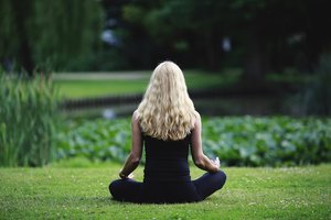 Gril meditating on grass