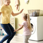 Woman And Daughter Dancing In Home