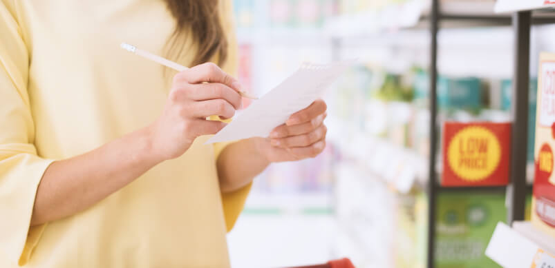 Woman With Shopping List In Store