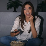 Woman watching TV And Eating Popcorn