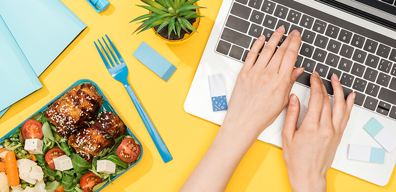 Person Working On Laptop With Lunch