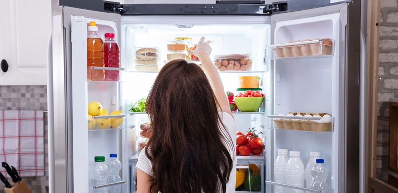 Woman organising fridge freezer