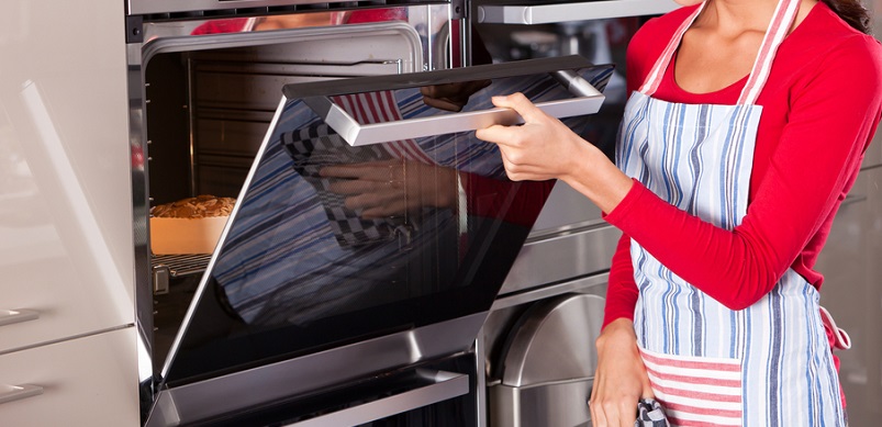 Woman opening oven door