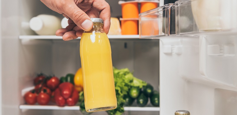 Hand putting bottle in fridge